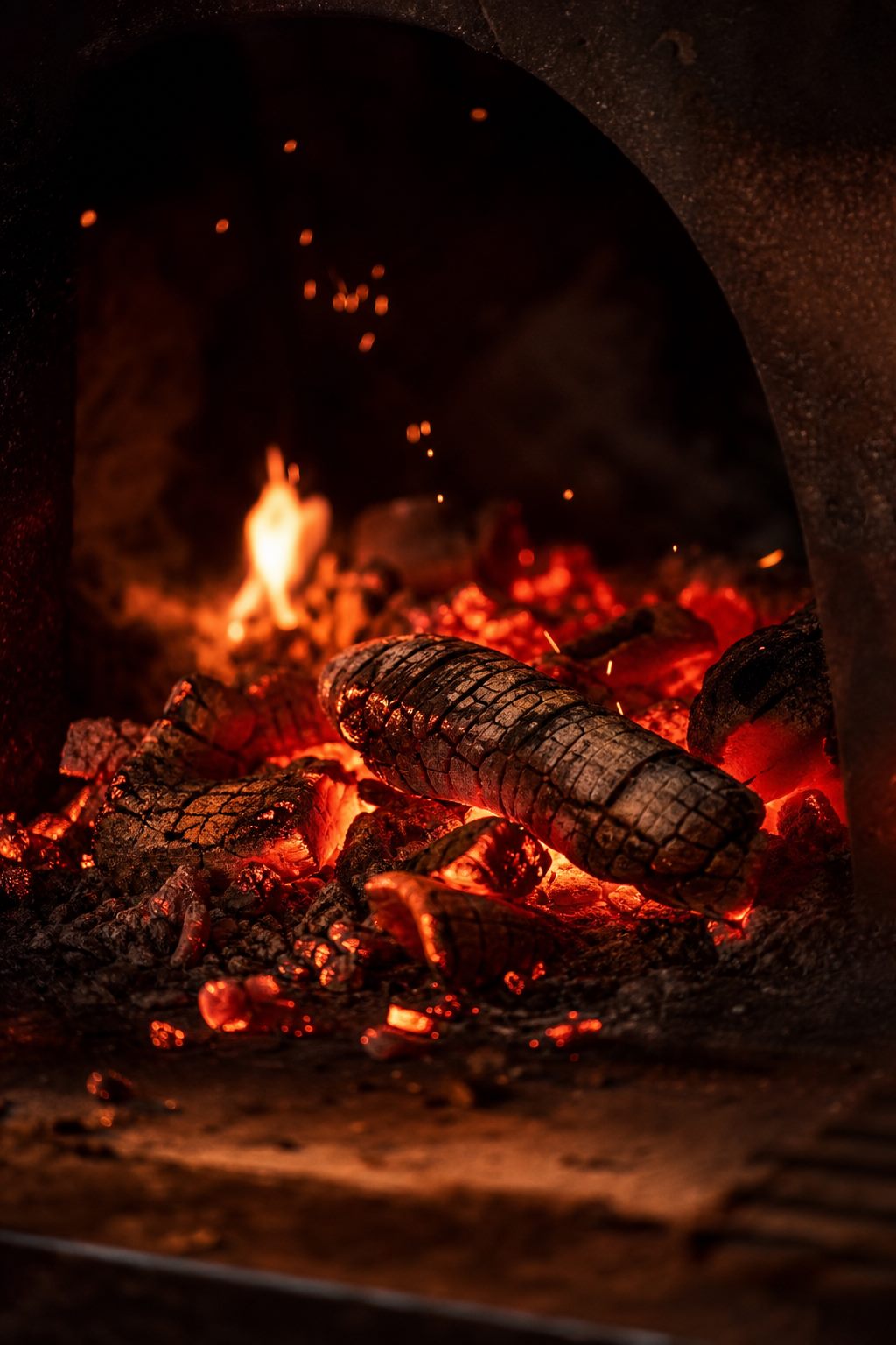 Glowing embers with sparks rising in the hearth